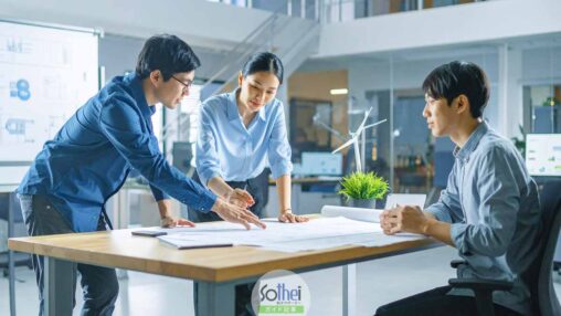 ３名のウェブデザイナーが打ち合わせをしているオフィス