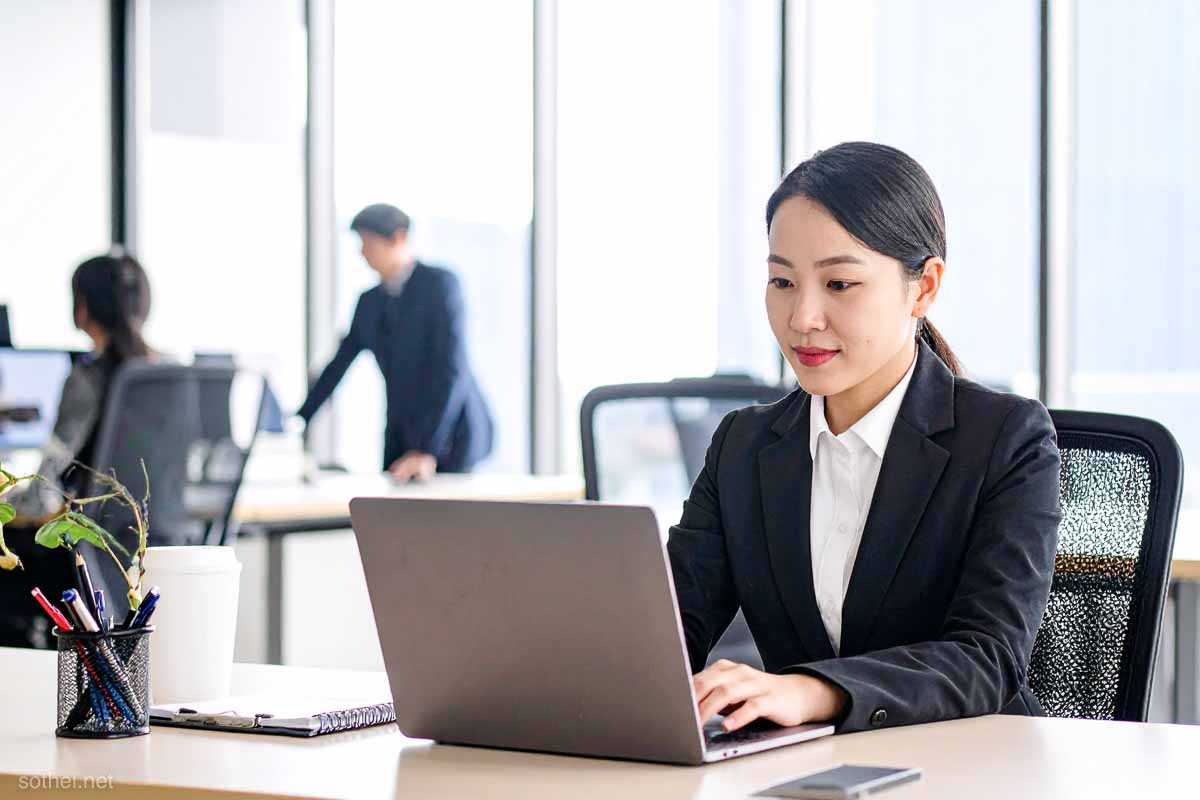 会社のデスクで仕事をする女性社員