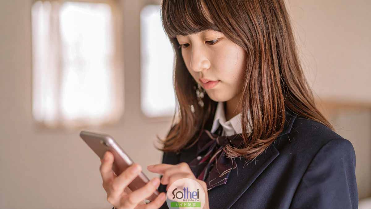 スマホをいじる女子高生